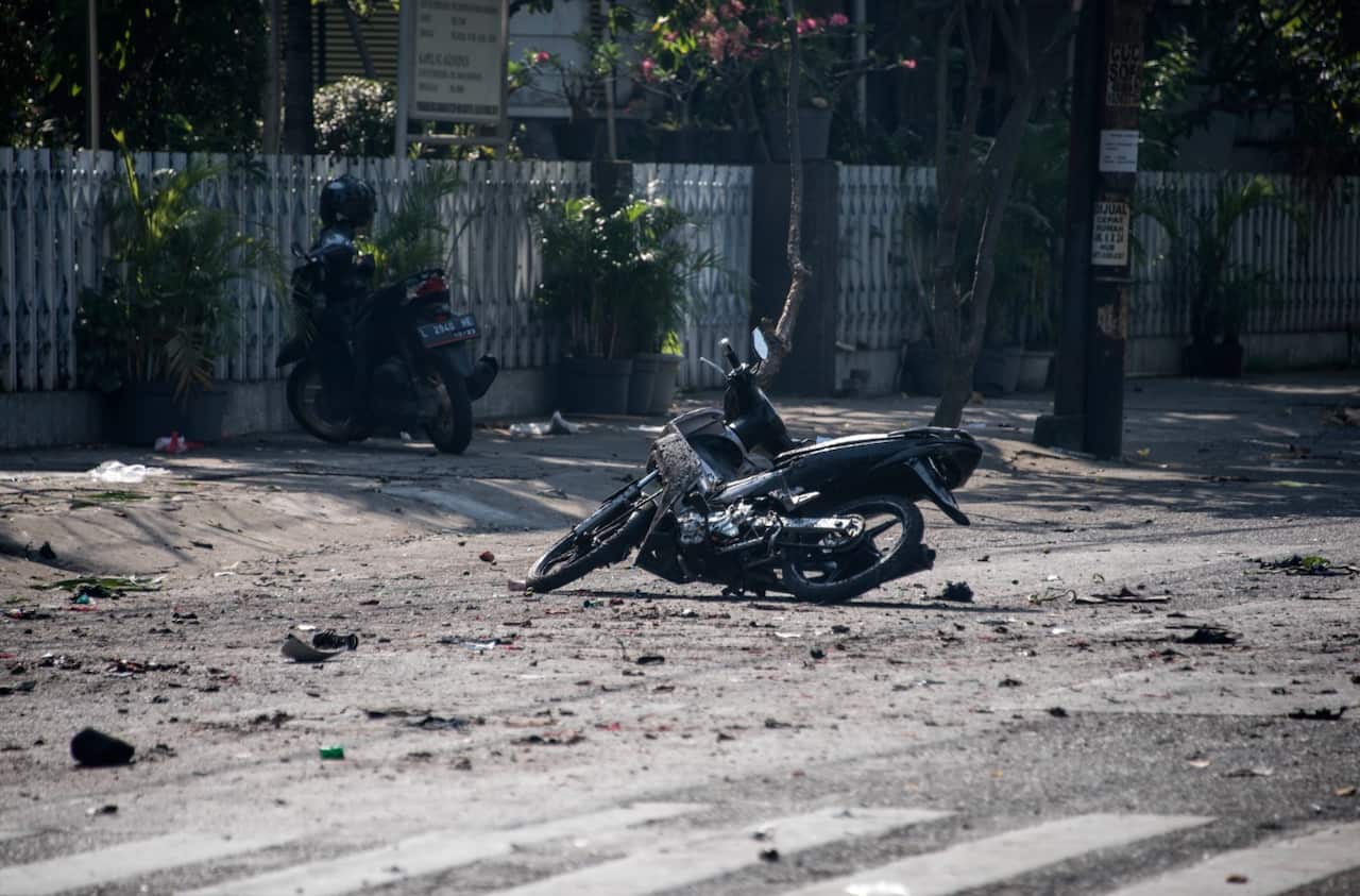 A damaged motorbike is seen at the scene outside a church following a suicide bomb in Surabaya on May 13, 2018.
