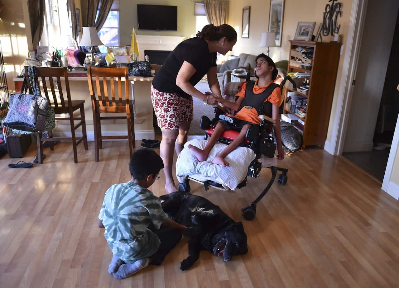 Kristin Keating shares a moment with son Michael, 10, as his twin brother, Chris, plays with their dog Shiloh at their home 50 miles west of Philadelphia. (Ricky Carioti/The Washington Post)