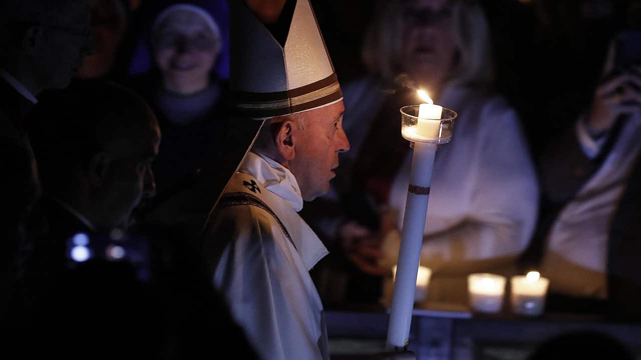 Pope Francis holds a candle during the Easter Vigil mass at the Saint Peter's Basilica in Vatican City.