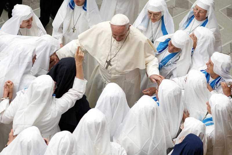 Pope Francis is greeted by a group of nuns at the Vatican.