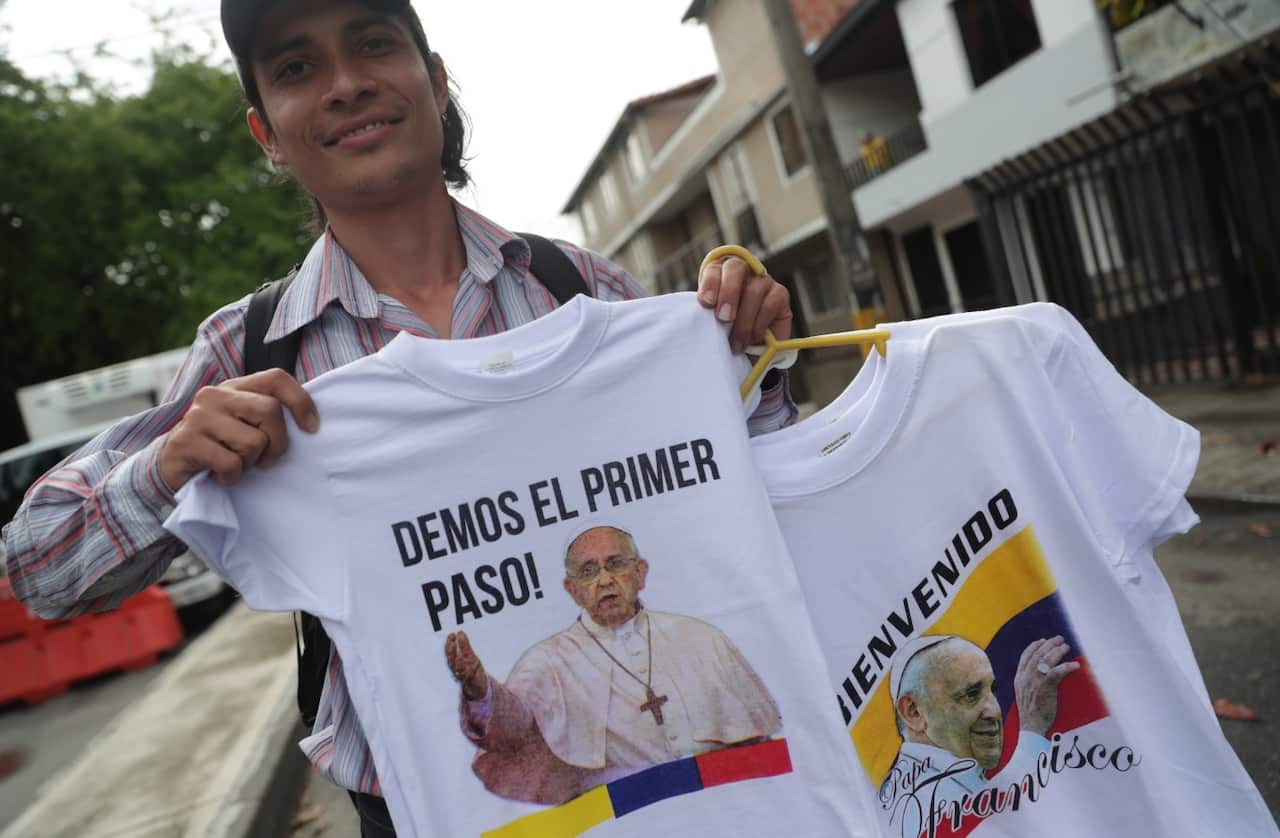 A man sells t-shirts with images of Pope Francis outside the Olaya Herrera airport ahead of the arrival of Pope Francis in Medellin (AAP)