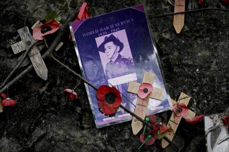 Roses and photographs laid in memory of those who died at the Hellfire Pass section of the Thai Burma railway.