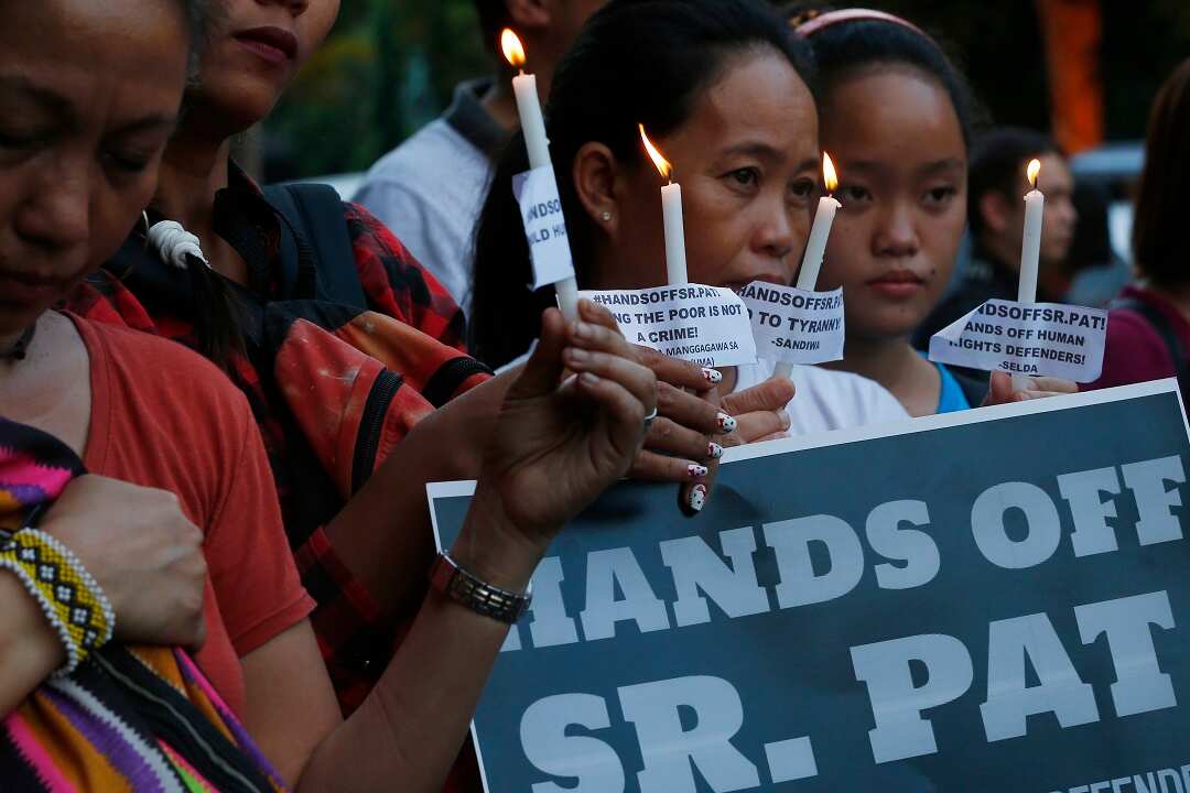 Supporters pray outside the Bureau of Immigration in Manila where Patricia Fox lodged an appeal against her deportation. 