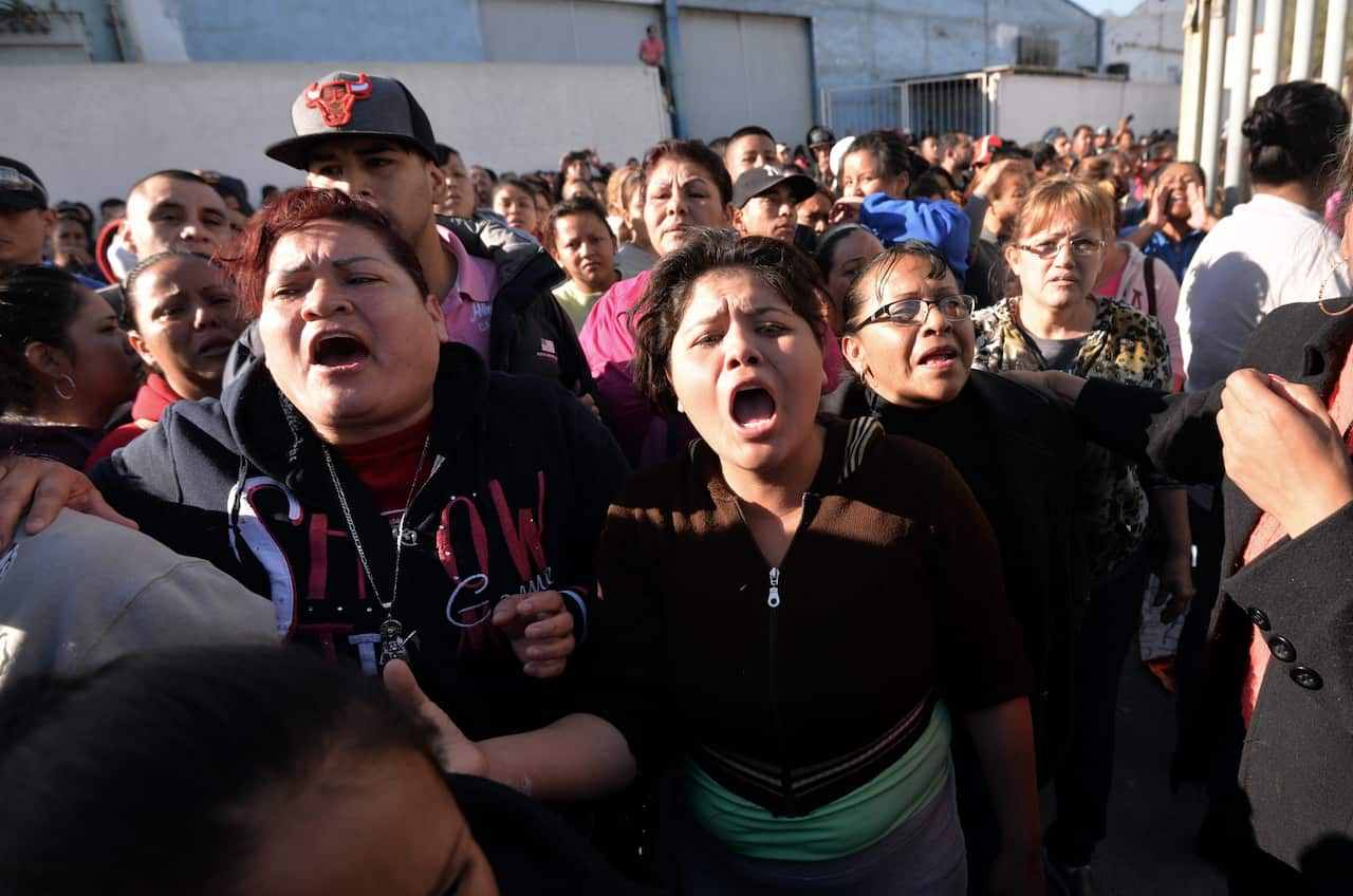 Relatives of inmates react outside the prison.