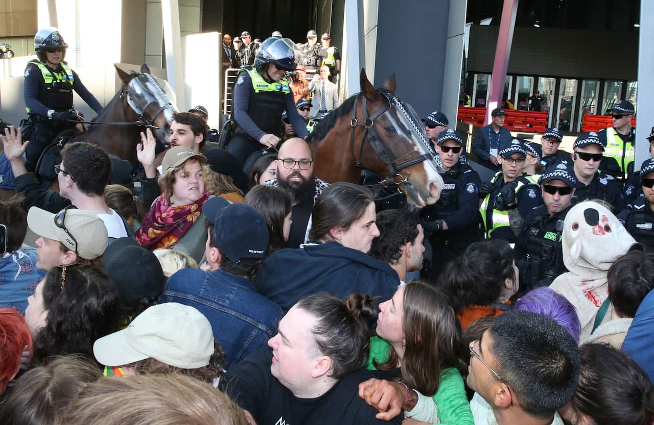 Mounted police move into the crowd of protesters outside the mining conference.