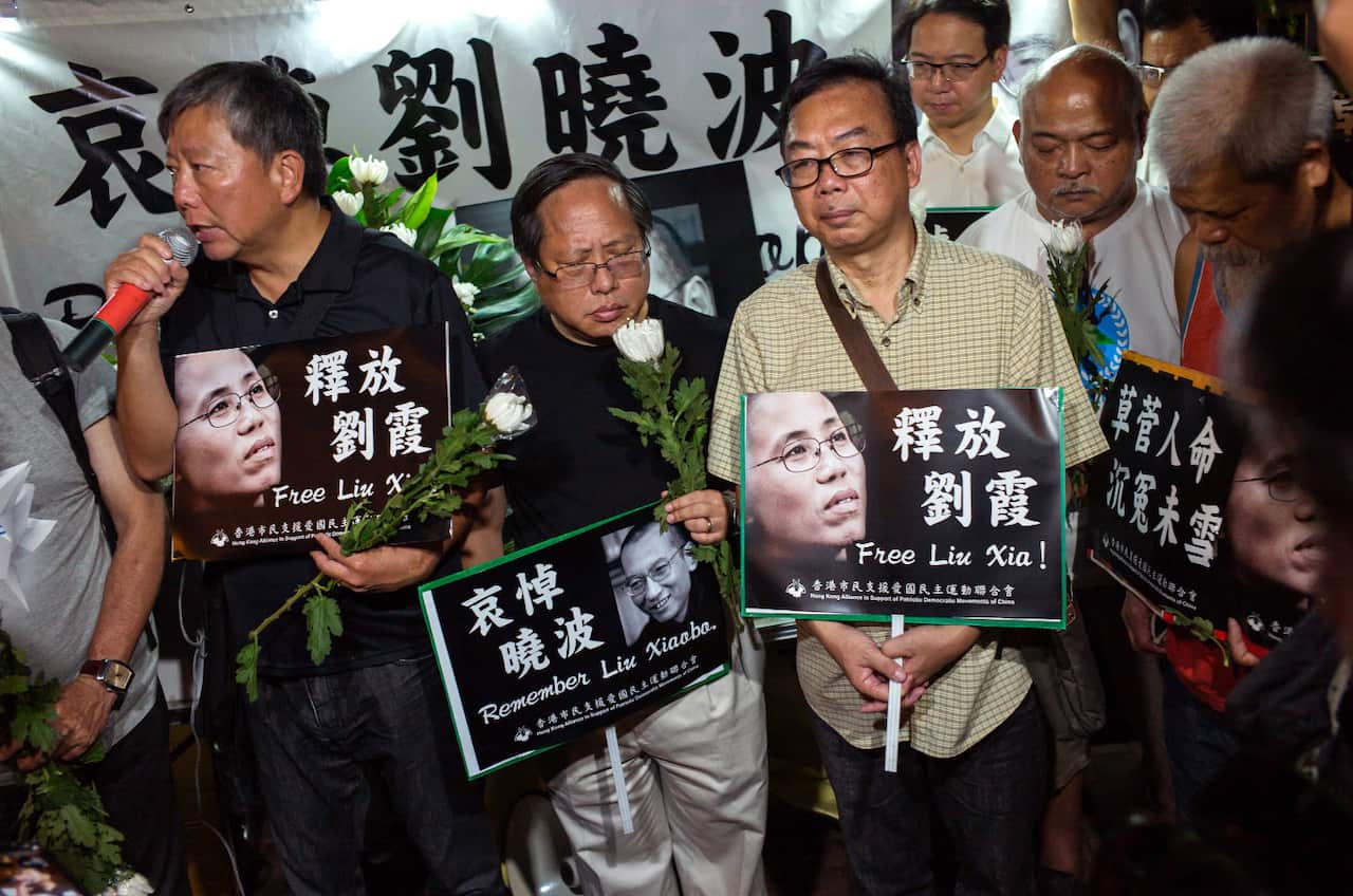 People mourn the death of jailed Chinese Nobel Peace laureate Liu Xiaobo during a demonstration outside the Chinese liaison office