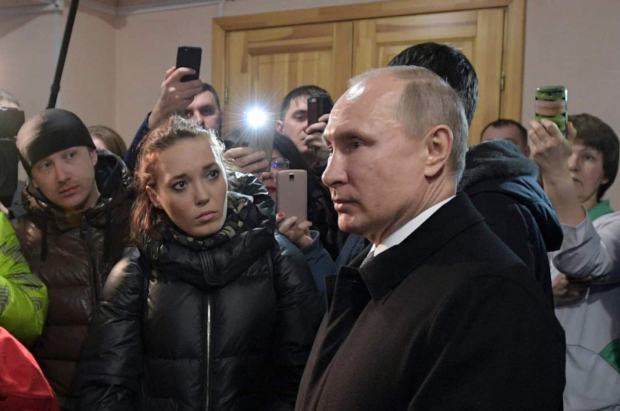 Russian President Vladimir Putin listens to locals and relatives of the victims of the fire.