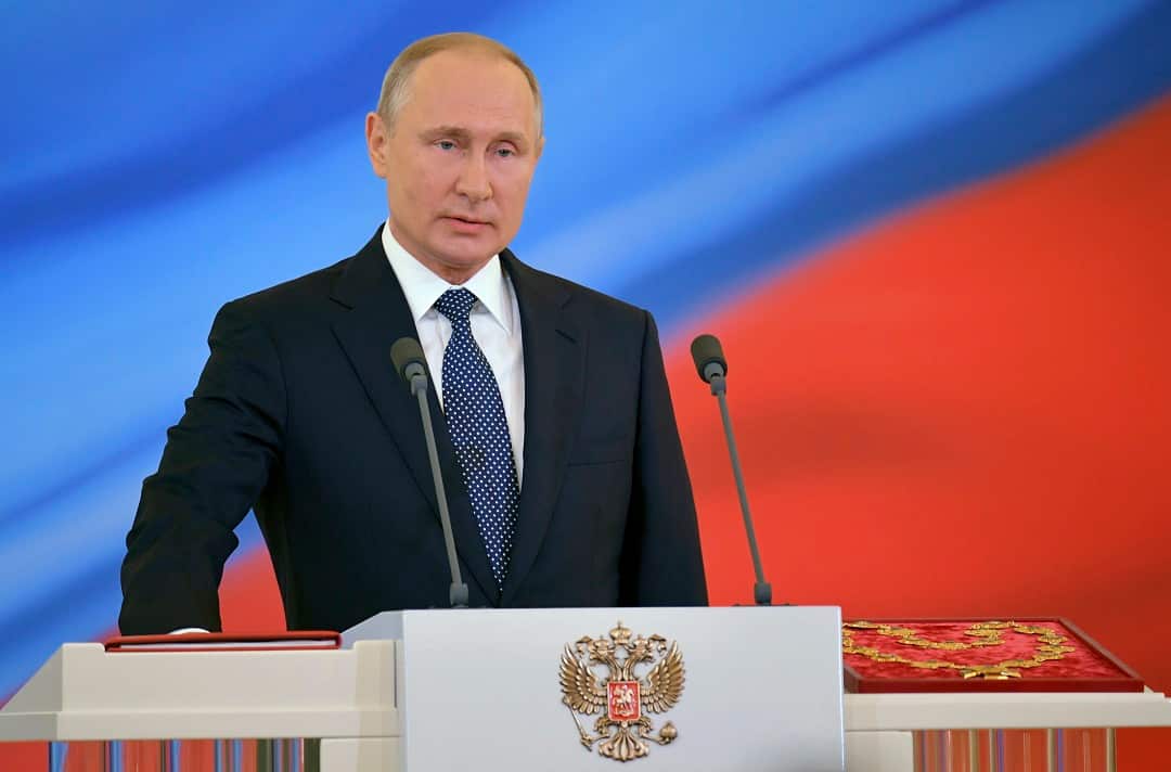Vladimir Putin speaks with his hand on the Constitution during his inauguration ceremony.