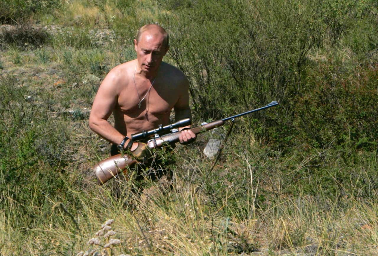 File: Russian President Vladimir Putin walks holding a rifle in the Tuva region of Siberia in this Wednesday, Aug. 15, 2007 (AAP)