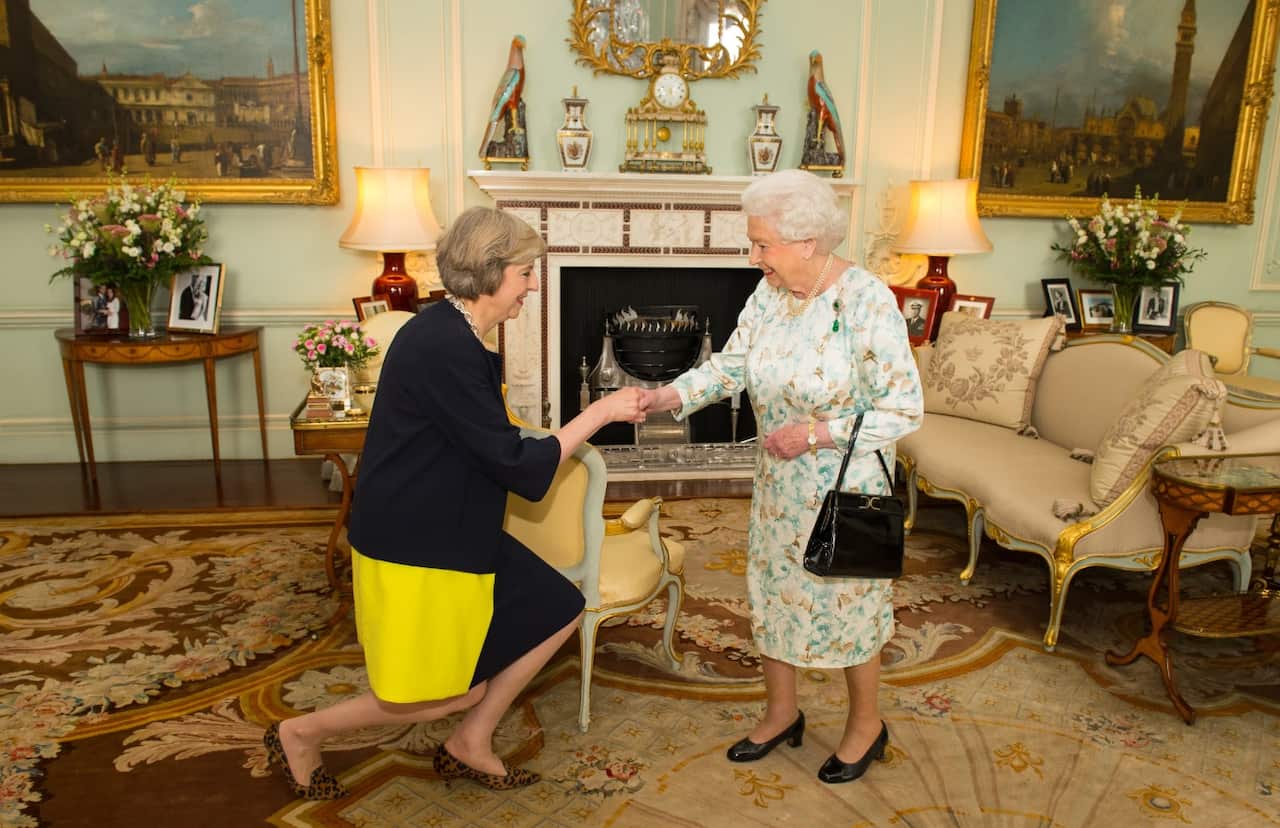 Queen Elizabeth II (R) welcomes Theresa May at the start of an audience in Buckingham Palace (AAP)