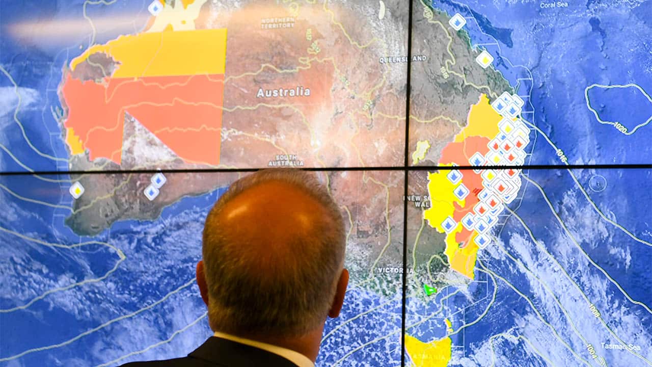 Australian Prime Minister Scott Morrison looks at a screen as he gets a briefing on the bushfire situation in New South Wales and Queensland.