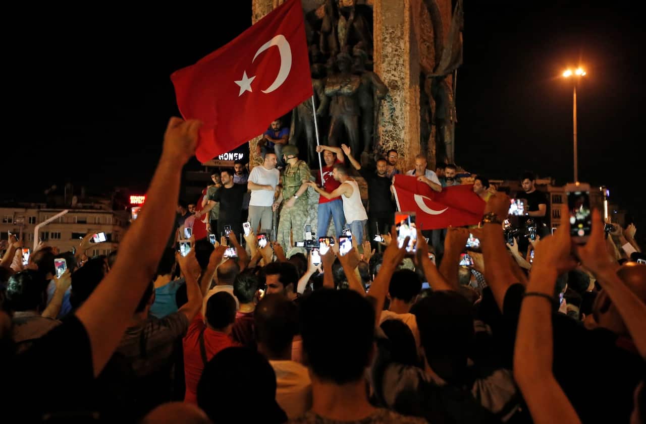 Supporters of Turkey's President Recep Tayyip Erdogan, gather, waving Turkish flags, in Istanbul's Taksim square, early Saturday, July 16, 2016. (AAP)