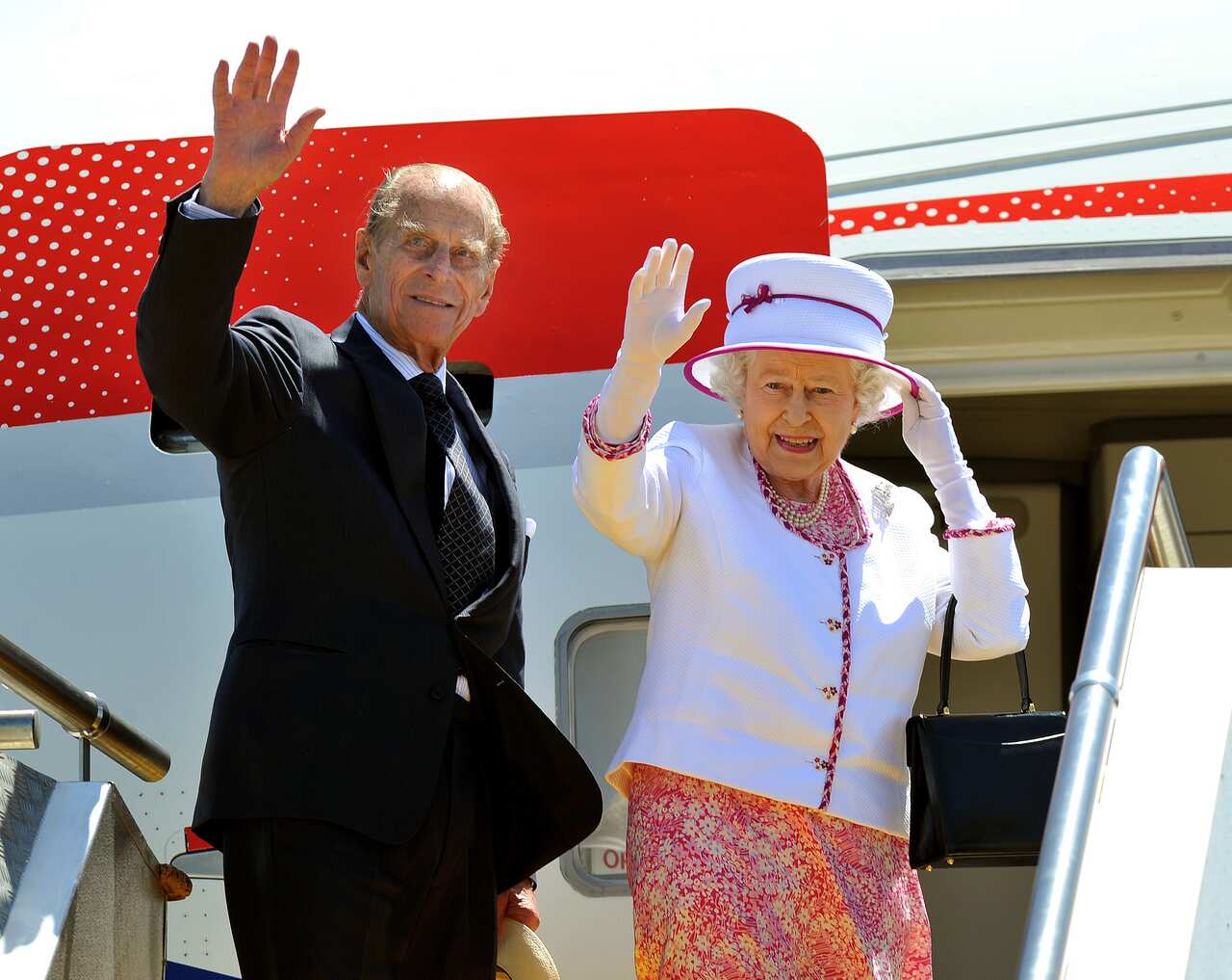 The Queen (right) and Prince Philip (left) stand at the top of aeroplane steps and wave goodbye at Perth Airport at end of 16th Royal Tour to Australia in 2011.