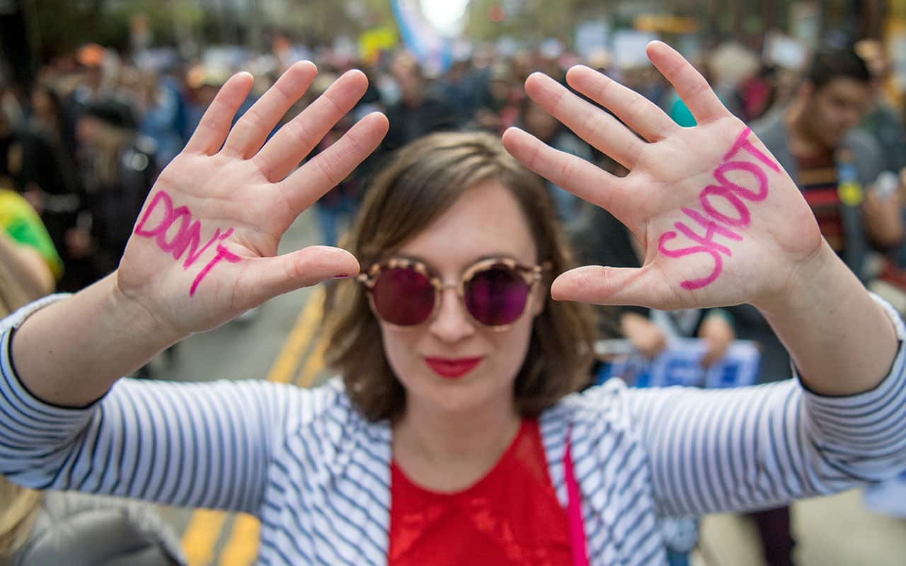 Jaime Spanik holds up her hands along with crowds of people as they participate in the "March for Our Lives" rally.