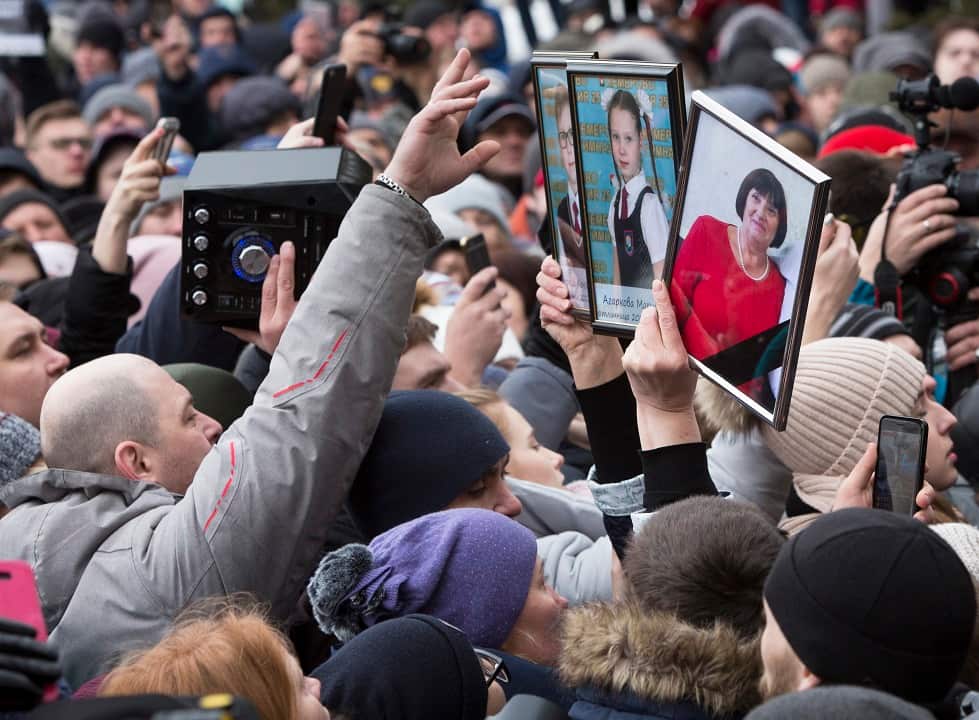 Mourners hold portraits of their dead relatives as they call for the resignation of the region's governor.