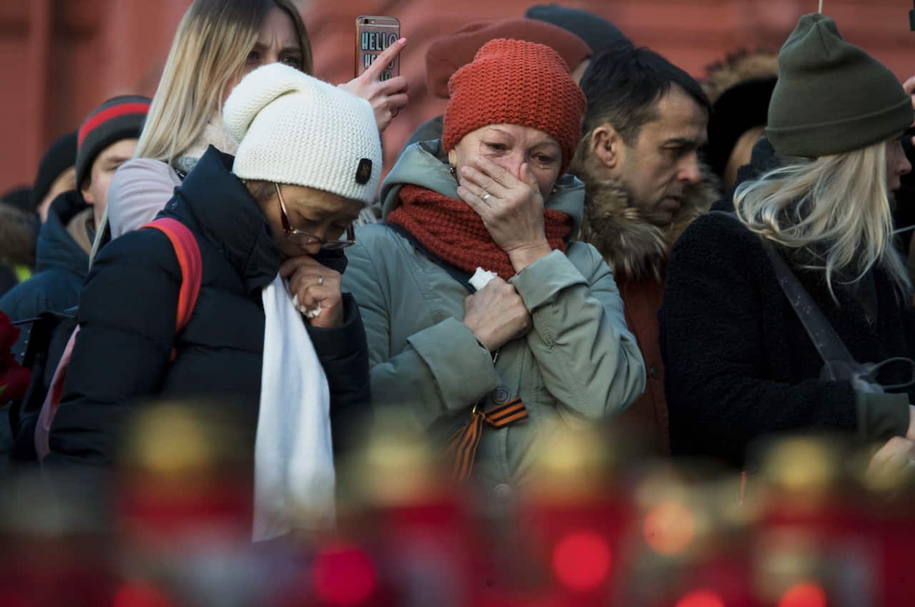 People lay flowers in Moscow for the victims of a fire in a shopping centre in Kamerovo.