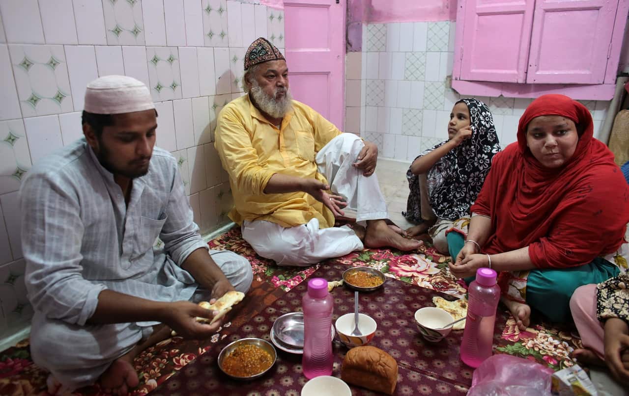 Mohammed Shafiq, a town crier, takes a pre-dawn meal during Ramadan with his family after making his rounds to wake neighbors in the Old Delhi quarter of New Delhi. 
