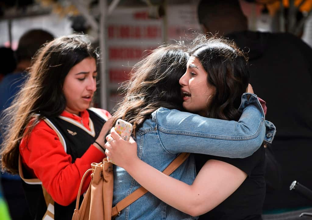 Friends embrace after shots were fired during the Toronto Raptors NBA basketball championship parade in Toronto.