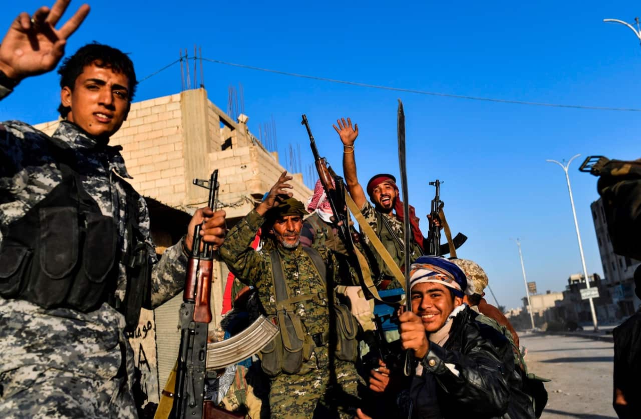 Members of the Syrian Democratic Forces (SDF), backed by US special forces, celebrate at the frontline in the IS group jihadists stronghold (Getty)