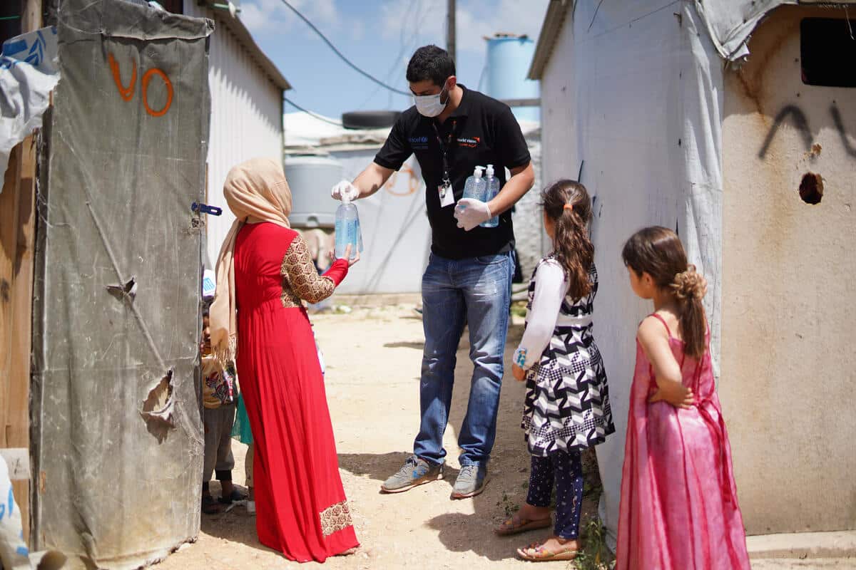 Receiving hand sanitizer in Beqaa refugee camp