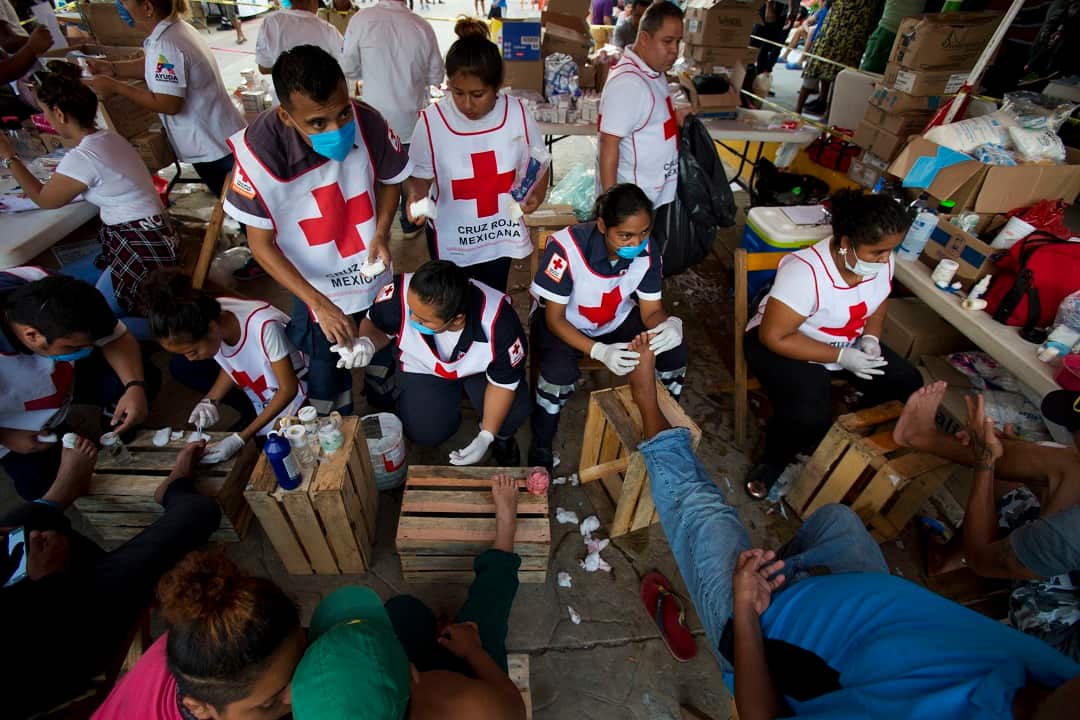 Volunteers from the Mexican Red Cross treat the blistered and cut feet of the Central American migrants.