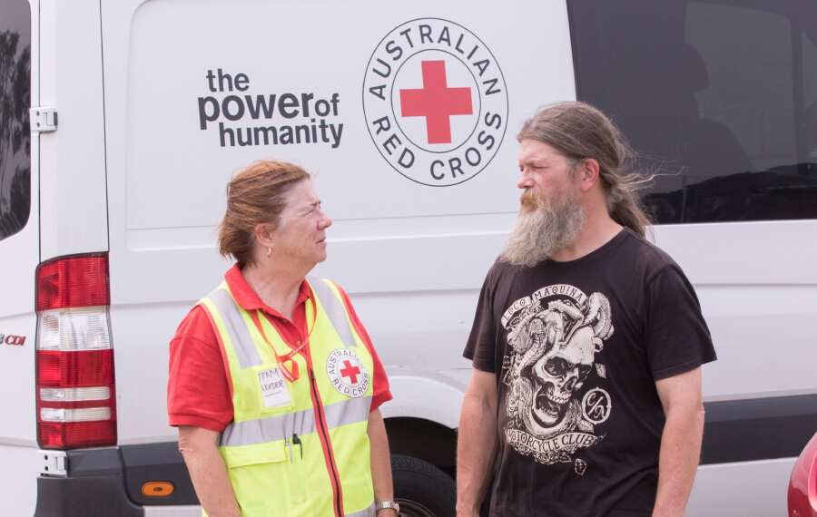A member of the Australian Red Cross speaks with a bushfire survivor.