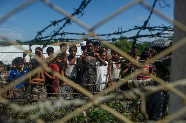 Rohingya refugees gather near the fence in the "no man's land" between Myanmar and Bangladesh.