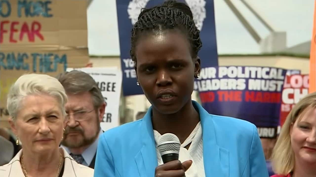 A South Sudanese refugee shares her story with those gathered outside Parliament House.