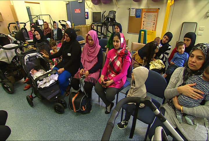 Migrant women wait at a practice.