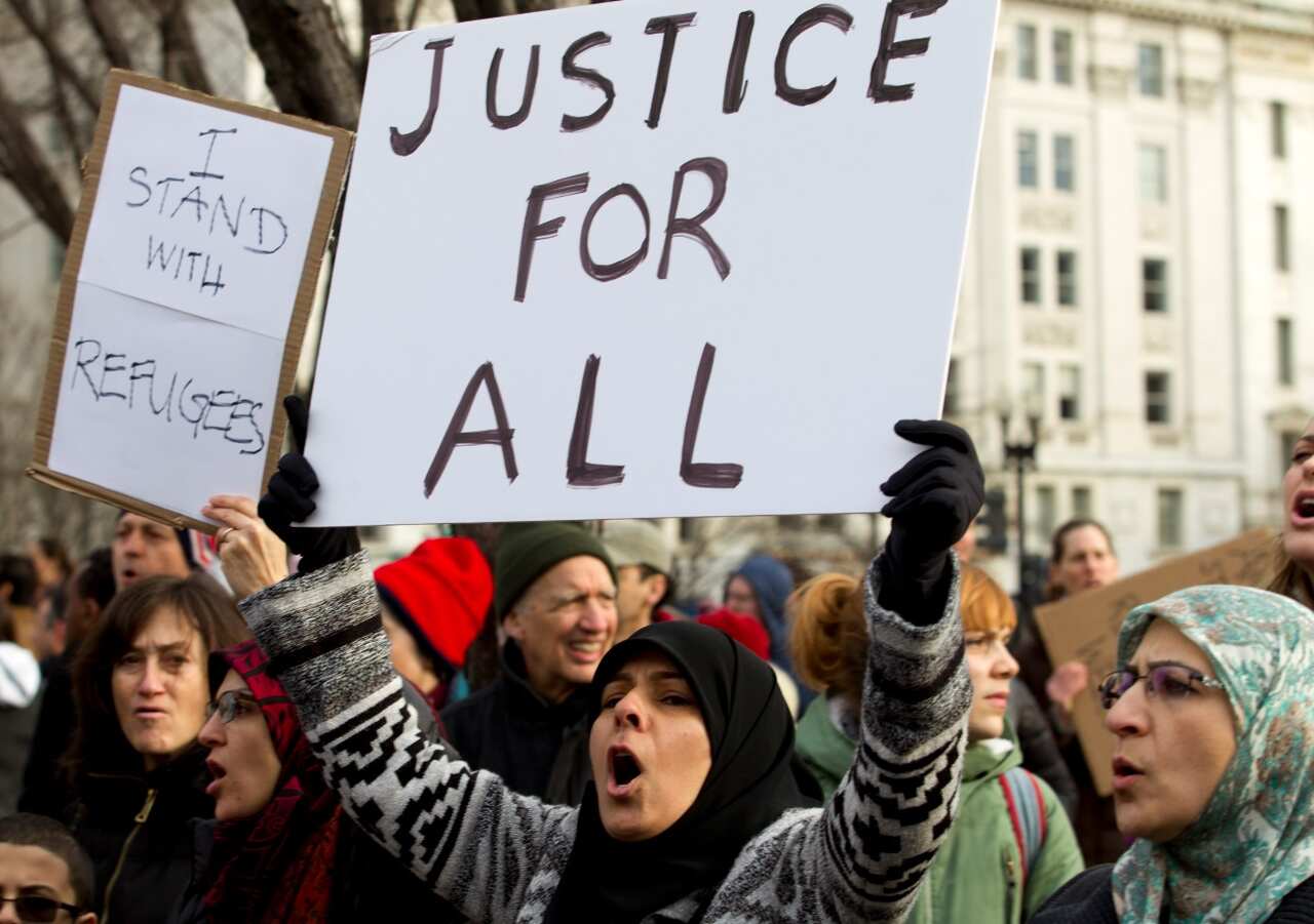 Demonstrators carrying signs chant as they protest outside of the White House during a demonstration to denounce President Donald Trump's executive order (AAP)