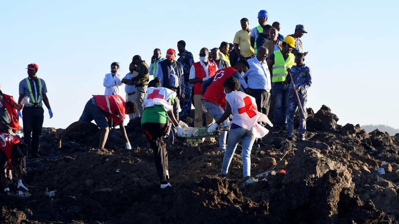Rescue workers carry wreckage at the crash site of Ethiopia Airlines Boeing 737 Max 8 en route to Nairobi, Kenya, near Bishoftu, Ethiopia.