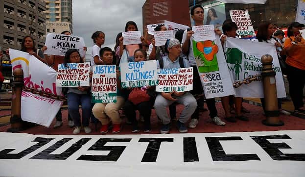 Protesters in Manila display placards during a rally to condemn the recent killings in President Rodirgo Duterte