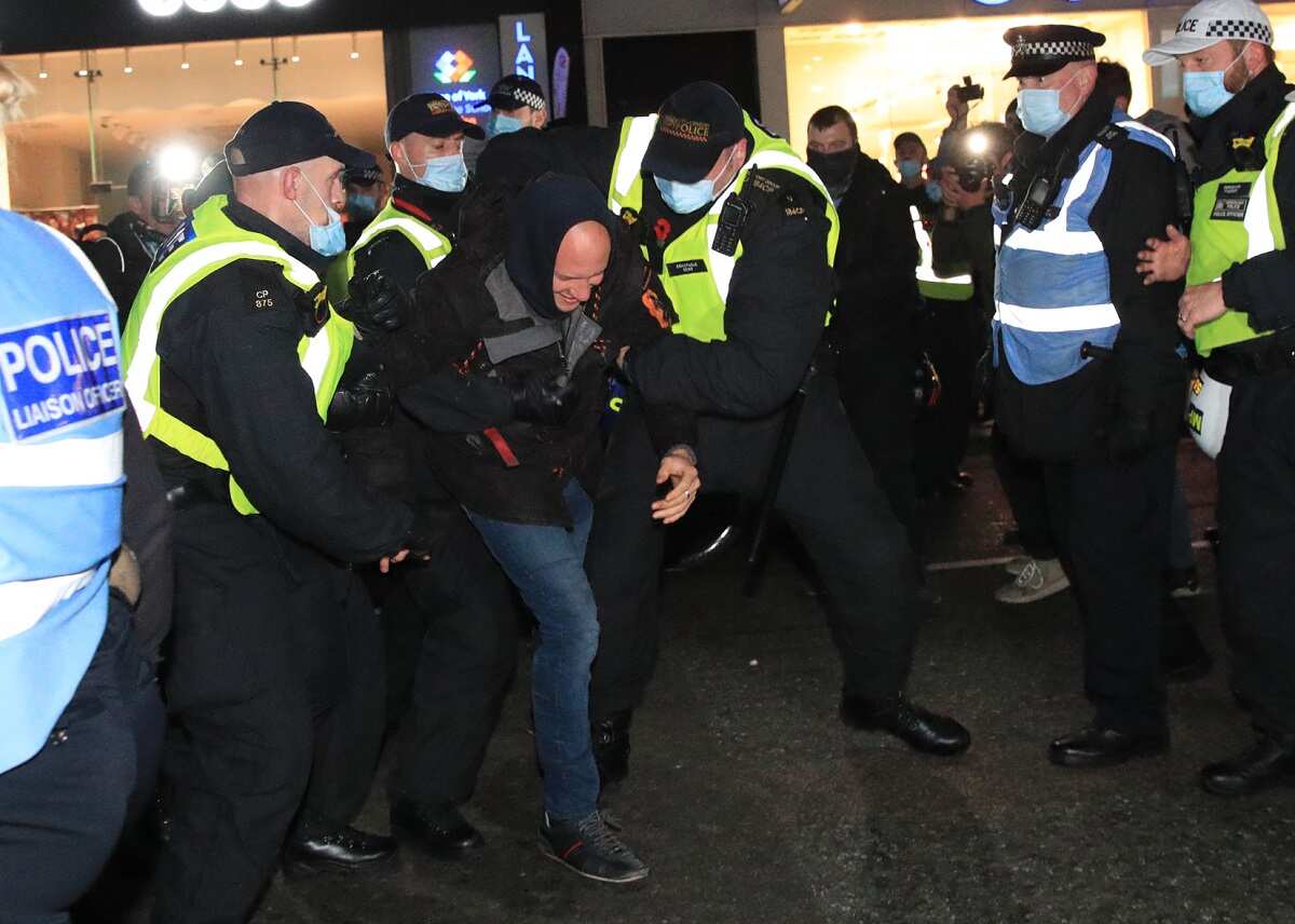 Police detain a protester during the Million Mask March anti-establishment protest in London, on the first day of a four week national lockdown for England.