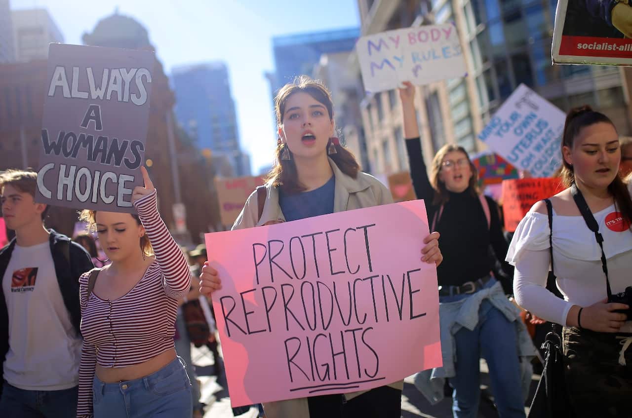 Protesters march with placards during the Our Body Our Choice march in Sydney, Sunday, June 9, 2019.