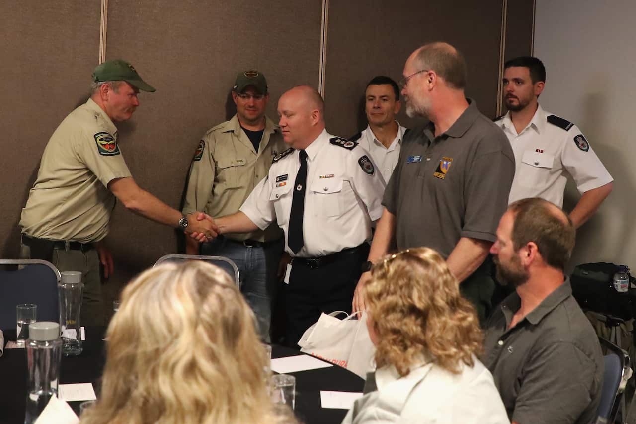 RFS Commissioner Shane Fitzsimmons shakes hands with international firefighters during a farewell to Canadian and US volunteers.