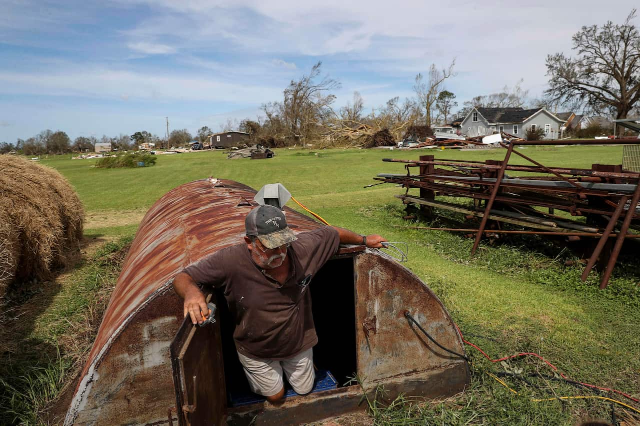 Ricky Thibadeaux emerges from a storm shelter where he and six others sheltered