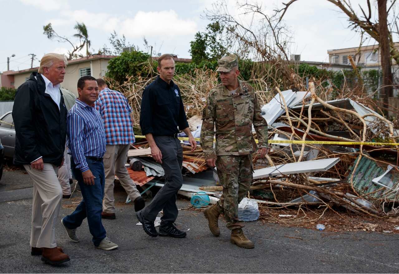 President Donald Trump and first lady Melania Trump tour a neighborhood impacted by Hurricane Maria, Tuesday, Oct. 3, 2017, in Guaynabo, Puerto Rico.