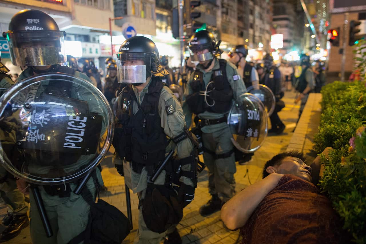  man sleeps in the park as anti-riot police conduct a clearing operation in Mongkok, Hong Kong.