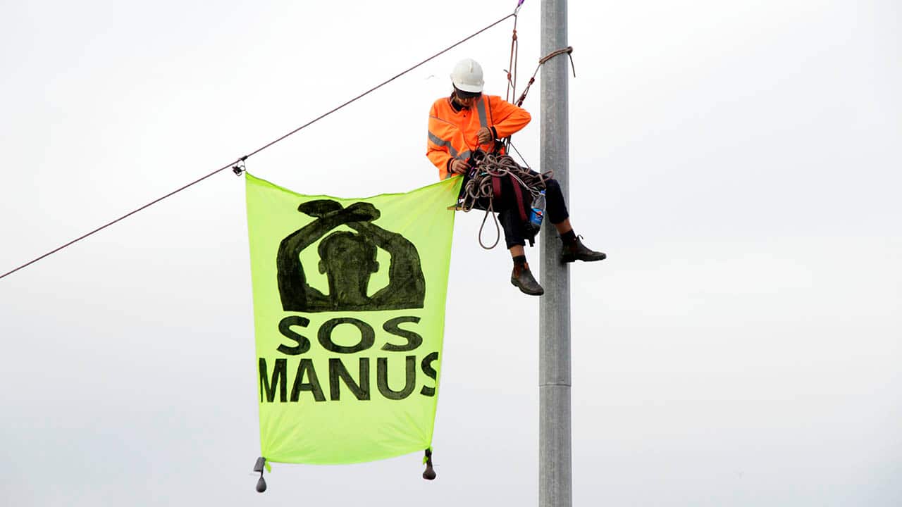 Activists block a Melbourne port container and unfurl banners.