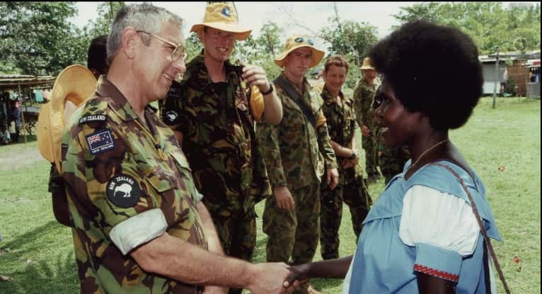 New Zealand Defence Force Brigadier Roger Mortlock shakes hands with a Bougainvillean woman.