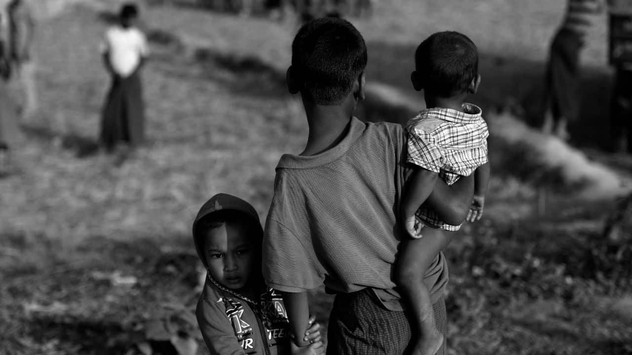 An older Rohingya child helps other children to cross a bamboo bridge in the Jamtoli refugee camp near Cox's Bazar in Bangladesh.