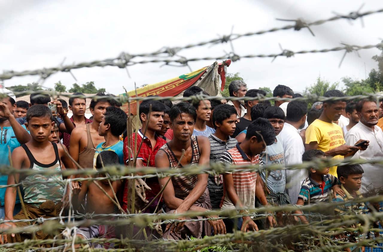 Rohingya refugees gather near a fence at the 'no man's land' zone at the Bangladesh-Myanmar border in Maungdaw district, Rakhine State, 24 August 2018.