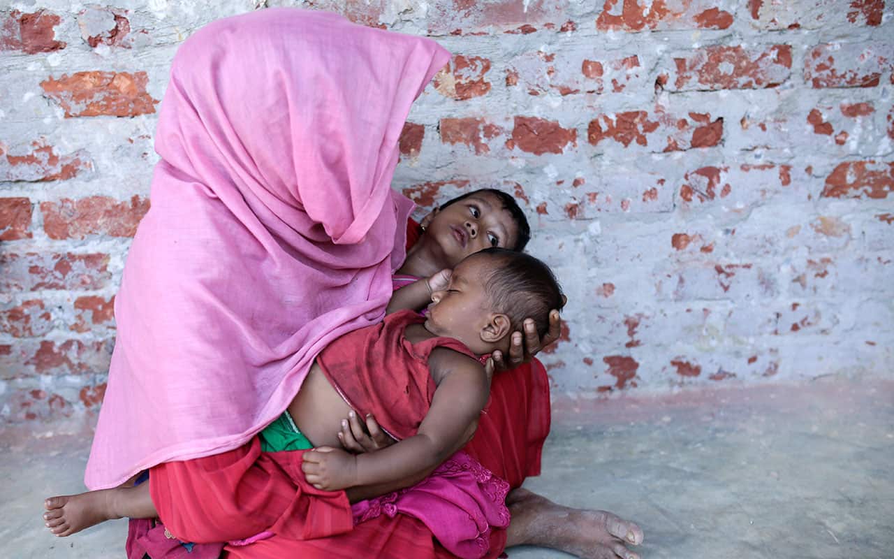 A Rohngya refugee waits with two sick children inside a health clinic for treatment at the Kutupalong, Coxabazar in Bangladesh November 19 2017.