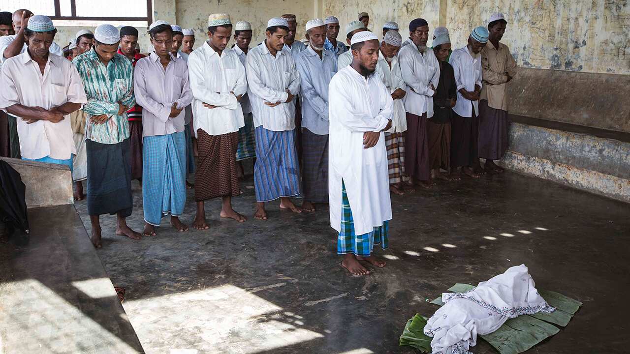 Rohingya Muslims mourn the death of a child in the camp