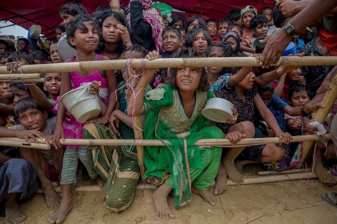 Rohingya Muslim children, who crossed over from Myanmar into Bangladesh, wait for their turn to collect meals distributed by Turkish aid agency.