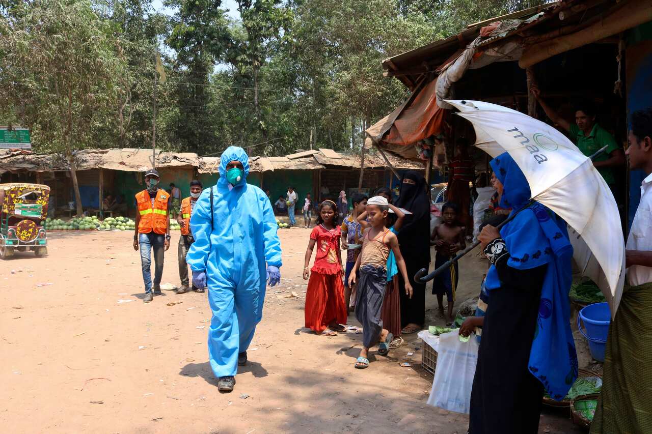 A health worker from an aid organization walks wearing a hazmat suit at the Kutupalong Rohingya refugee camp in Cox's Bazar, Bangladesh. 