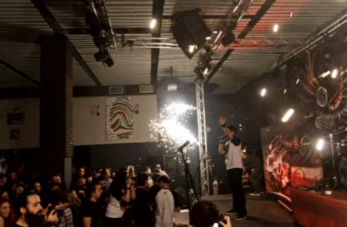 A member of the Romanian metal band 'Goodbye to Gravity' performs as firewoks erupt on the stage of a nightclub, before a fire broke out