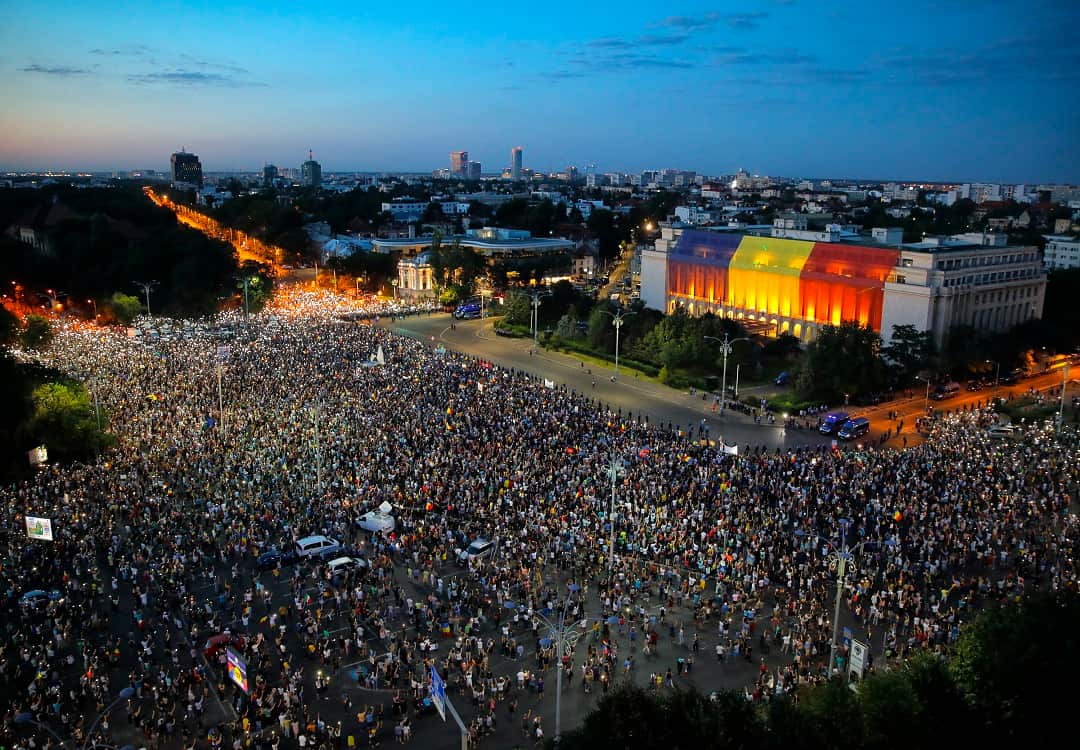 People shine the lights of their mobile phones during a protest outside the government headquarters in Bucharest.