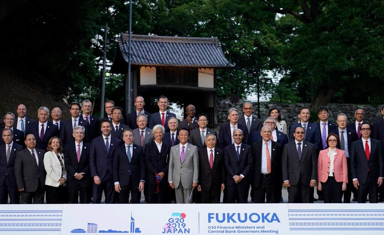 Japan's Finance Minister Taro Aso, center, poses next to IMF Managing Director Christine Lagarde, center left, and Bank of Japan Governor Haruhiko Kuroda