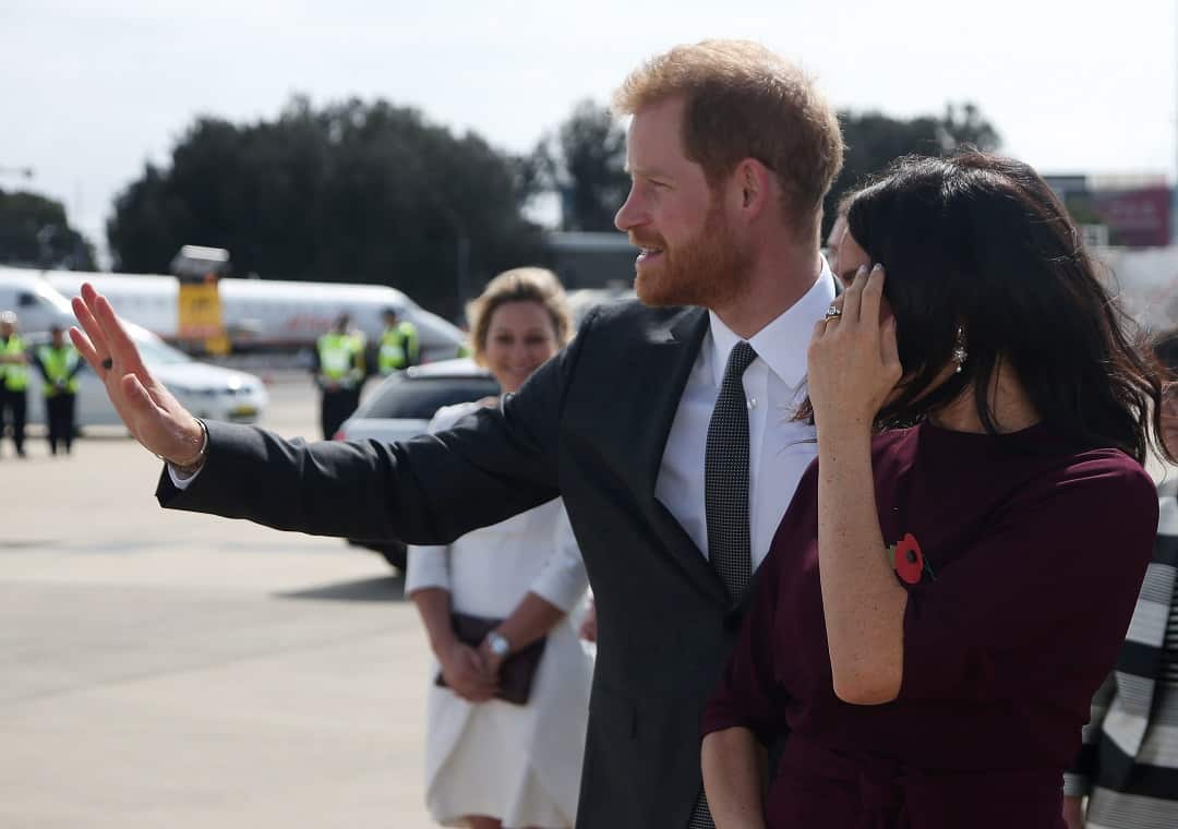 Prince Harry and his wife, Meghan, the Duchess of Sussex, wave as they prepare to depart Australia.